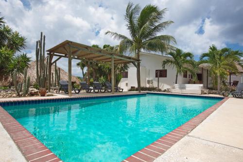威廉斯塔德Bantopa Apartments的一个带凉亭和棕榈树的游泳池