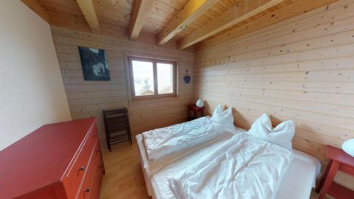贝拉尔普Alpenlodge的一间卧室设有一张床和木墙