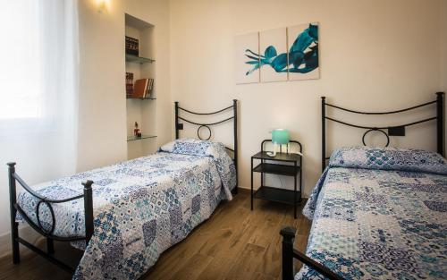 卡利亚里Wonderful apartment in Cagliari center的一间卧室配有两张带蓝色棉被的床