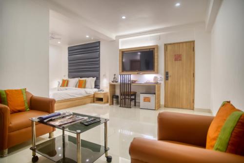 加尔各答罗兰德酒店的客厅配有沙发和桌子