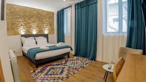 波尔多AMA的一间卧室配有一张带蓝色窗帘和地毯的床