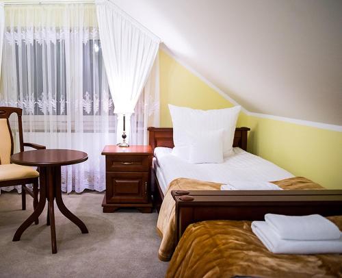 华沙BTHouse, Pokoje Gościnne的一间卧室配有一张床、一张桌子和一个窗户。
