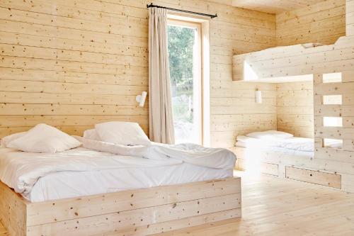 VrenaLindeborgs Eco Retreat的木间设有两张床,设有窗户
