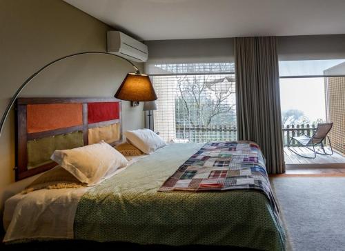 圣托·蒂尔索Quinta das Leiras的一间卧室设有一张大床和大窗户
