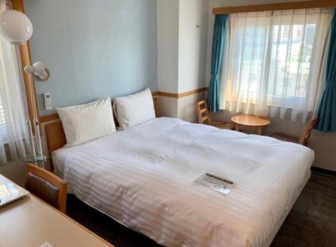 首尔Toyoko Inn Seoul Dongdaemun I的卧室配有一张白色的大床和一张桌子