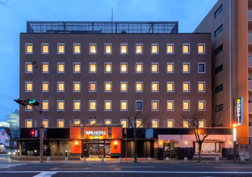 佐贺市APA佐贺站前酒店 的城市街道上的建筑,有交通灯