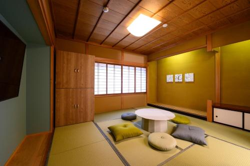 高山BEYOND HOTEL Takayama 4th的一间设有桌子的房间,有些枕头位于地毯上