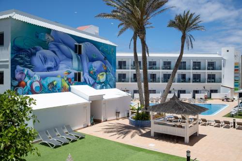 科拉雷侯Corralejo Surfing Colors Hotel&Apartments的一座带游泳池的建筑的侧面壁画