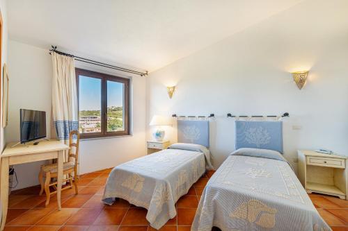 罗格桑托圣特兰诺酒店的配有书桌和窗户的客房内的两张床