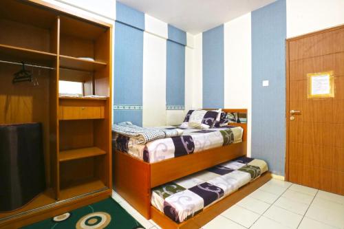 德波Dewi Depok Apartment Margonda Residence 2的蓝色和白色条纹间内的两张床