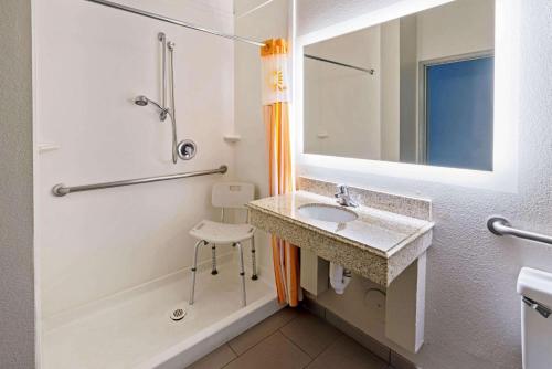 凤凰城凤凰城I-10西拉昆塔酒店的浴室配有水槽、淋浴和浴缸。