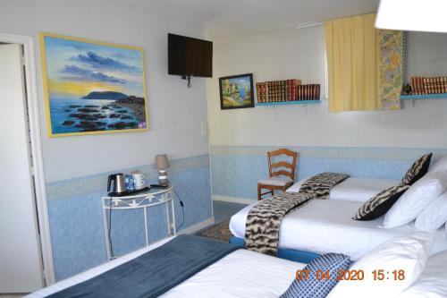 Brissac-Quincé乐卡斯特酒店的酒店客房设有两张床和一张桌子。