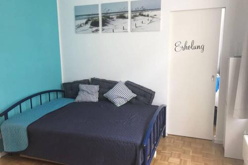 威斯巴登Central, Modern, mit großem Balkon Checkin123的一间卧室配有一张带蓝色床单和枕头的床。
