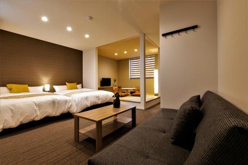 泉佐野Apartment Hotel STAY THE Kansai Airport的酒店客房,设有两张床和一张沙发