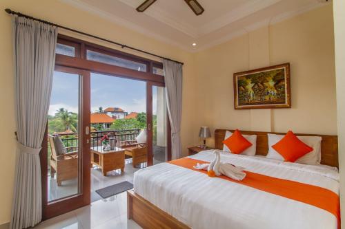 乌布乌玛阿尼拉旅馆的一间带大床的卧室和一个阳台