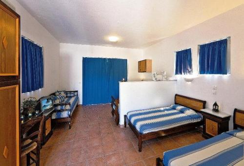 拉多斯卡缇吉斯公寓酒店的带两张床的客房和一个带蓝色窗帘的厨房