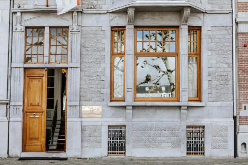 马斯特里赫特Maison Haas Hustinx & Spa的一座带窗户和木门的建筑