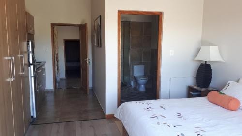 乔治Oubaai Ocean View Private Self catering rooms Herolds Bay的一间带白色床的卧室和一间浴室