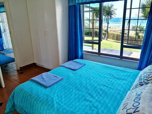 马盖特Southern Comfort - Starfish的一间卧室配有一张带蓝色床单的床和一扇窗户。