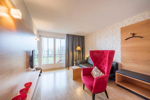 博登斯边的伊门施塔特Appartementhotel Röhrenbach的客厅配有红色椅子和沙发