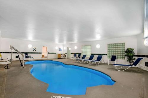 达尔哈特La Quinta by Wyndham Dalhart的一个带椅子和桌子的房间的游泳池