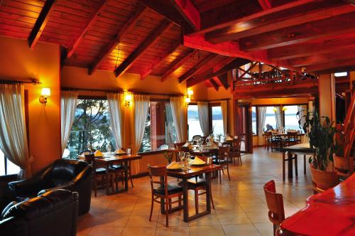 圣卡洛斯-德巴里洛切翠明私人豪华Spa酒店的一间在房间内配有桌椅的餐厅