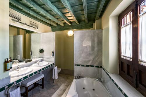 格拉纳达卡萨莫里斯卡酒店的浴室配有两个盥洗盆和浴缸。