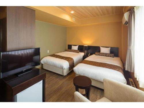 仙北Tazawako Lake Resort & Onsen / Vacation STAY 78983的酒店客房设有两张床和一台平面电视。