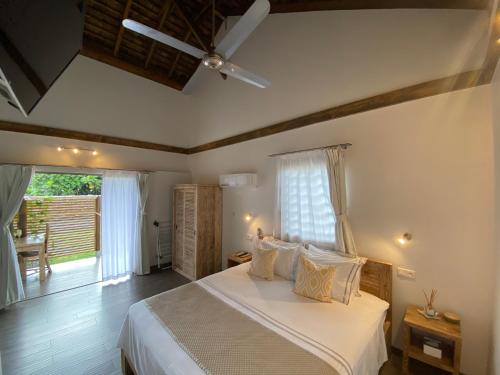 MariutiFare noanoa的一间卧室配有一张带白色床单的床和一扇窗户。