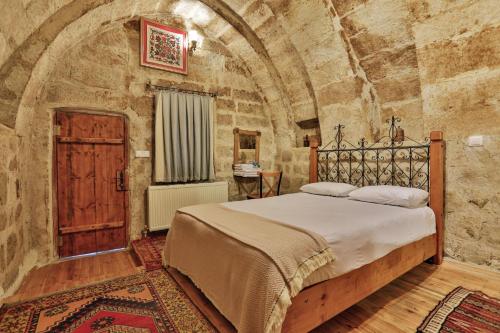 格雷梅笑翠鸟酒店的卧室配有一张石墙内的大床