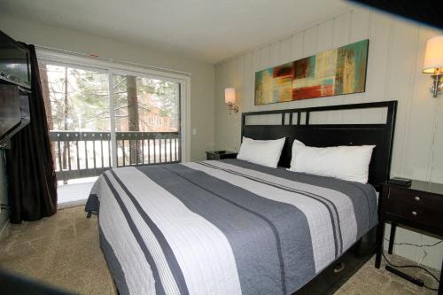马姆莫斯湖Sierra Park Villas #03的一间带大床的卧室和一个阳台