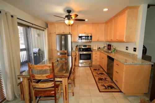 马姆莫斯湖Sierra Park Villas #82的厨房配有木制橱柜和桌椅