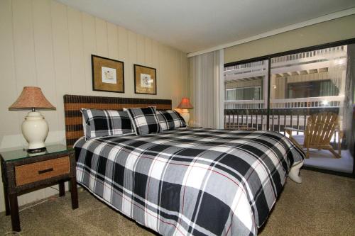 马姆莫斯湖Sierra Park Villas #89的卧室设有黑白床和窗户。
