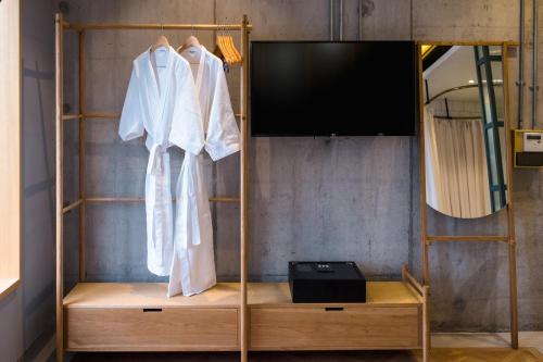 吉隆坡克洛伊酒店的衣柜配有电视和白色浴袍