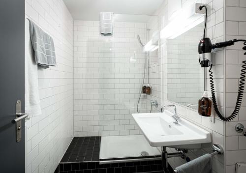 苏黎世好运旅馆的白色的浴室设有水槽和淋浴。