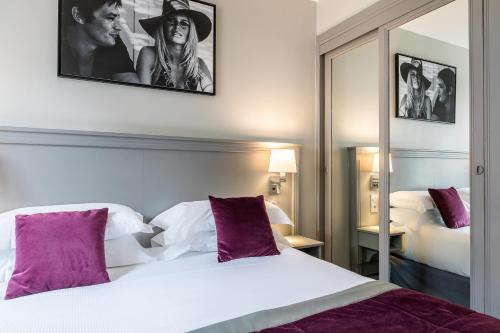 巴黎贝斯特韦斯特蒙加尔姆酒店的卧室配有一张带紫色枕头的大型白色床。