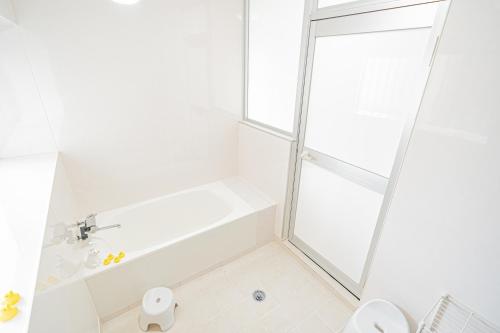 那霸Dot House Naha的带淋浴和卫生间的白色浴室
