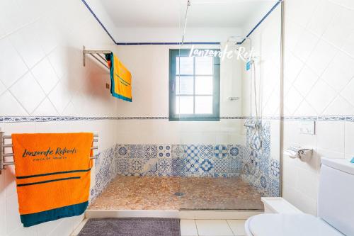 蓬塔穆赫雷斯Casa Lila的浴室设有蓝色和白色瓷砖淋浴。