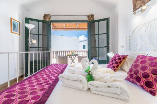 蓬塔穆赫雷斯Casa Lila的一间卧室配有带粉色和白色毛巾的床