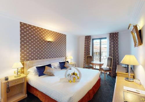 戛纳太阳里维拉酒店的酒店客房设有一张大床和大型床头板