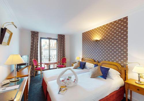 戛纳太阳里维拉酒店的酒店客房带一张床、一张桌子和椅子