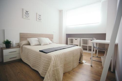 桑坦德Estilo nordico Sardinero的白色卧室配有床和书桌