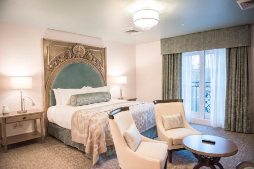 莱茵贝克Mirbeau Inn & Spa, Rhinebeck的卧室配有一张床和一张桌子及椅子