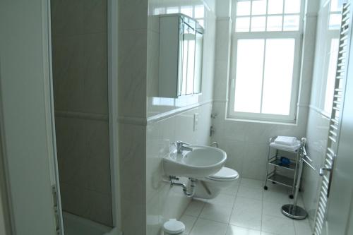 瓦尔内明德Residenz am Strande的白色的浴室设有水槽和镜子