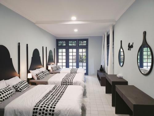 普卡Villa Airis By The Villas 100的一间设有两张床和两面镜子的客房