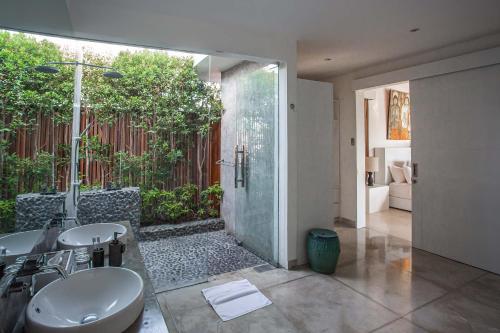 金巴兰CassaMia Bali - Spacious Luxury 5 Bedroom Villa, 100m from Beach with Butler的一间带两个盥洗盆和淋浴的浴室