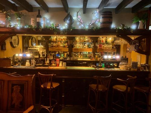 埃德尔斯顿The Horseshoe Inn的一间酒吧,在房间内配有酒吧凳子