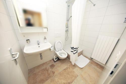 日内瓦Cozy Apartment close to Cornavin Train Station and lake的白色的浴室设有水槽和卫生间。