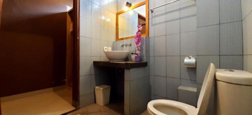 普卢坎The point surfcamp Bali的浴室配有卫生间和水槽。
