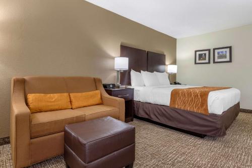 科尼利厄斯诺曼湖舒适套房酒店 的配有一张床和一把椅子的酒店客房